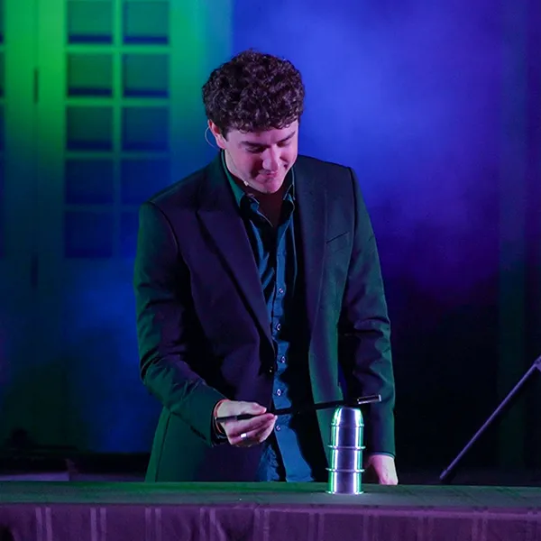 Jackson performing the cups and balls illusion